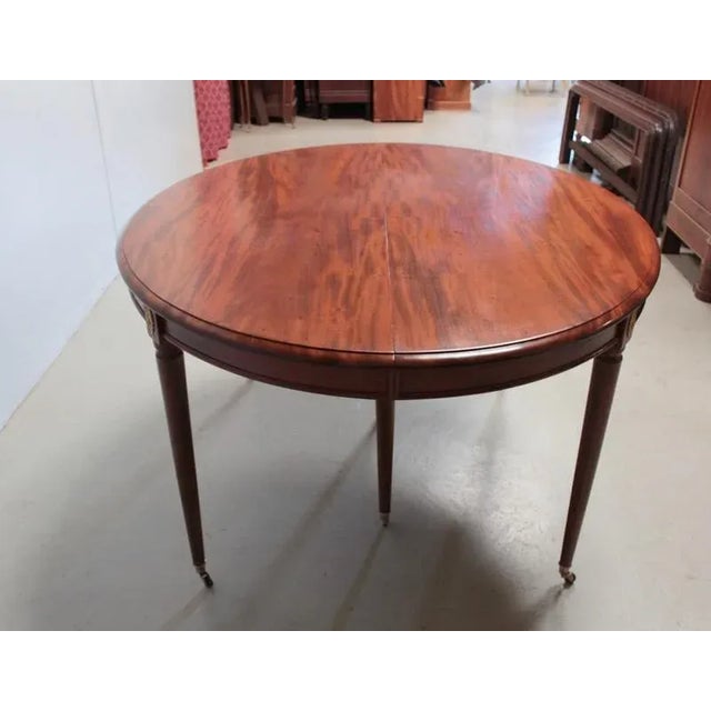 Large oval table in mahogany belt in the style of Louis XVI, based on 6 tapering legs ending in casters and upholstered in...