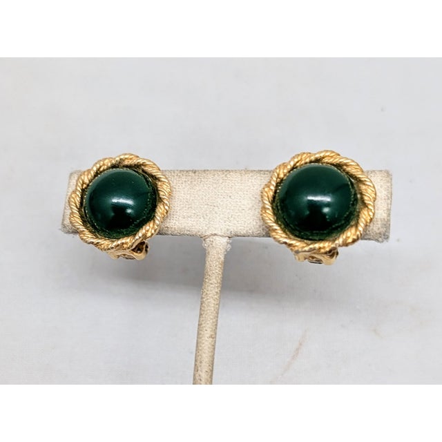 1950s round goldtone cabochon faux-dark green jade clip earrings. Marked "Carnegie" in script on the clips. Measure: 7/8...