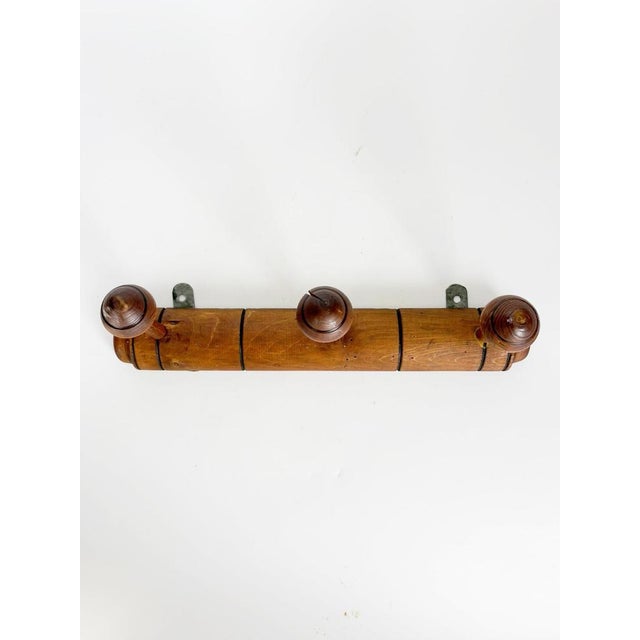 Rustic French wall-mounted coat rack dating from the 1930s, crafted from solid wood with a warm brown patina. Featuring...
