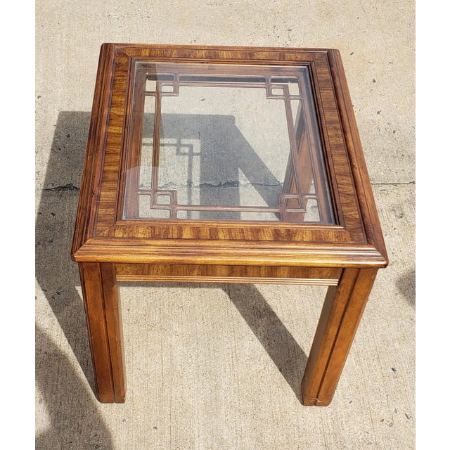 A beautiful natural finish square table made of solid Walnut. The tabletop has a geometric design pattern and a glass top....