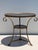 Patinated brass and black granite French style round Gueridon table with cast lion paw feet and center finial.