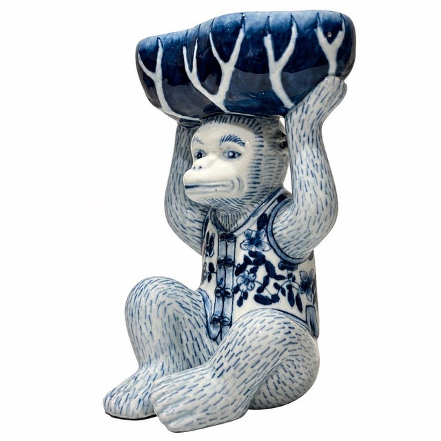 A lovely and whimsical blue and white chinoiserie pedestal bowl featuring a charming monkey holding a cabbage overhead....