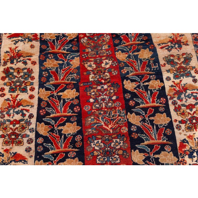 A decorative early 20th century Persian Shiraz antique carpet with five columns in red, ivory and black containing floral...
