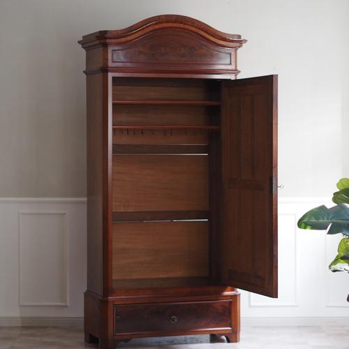 A single-door wardrobe with a mirrored door and a base drawer, stylistically attributable to the Louis-Philippe period...