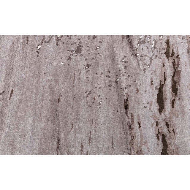 A contemporary hand-knotted silk and wool rug in shades of beige and brown, designed by Brett Beldock for Doris Leslie...