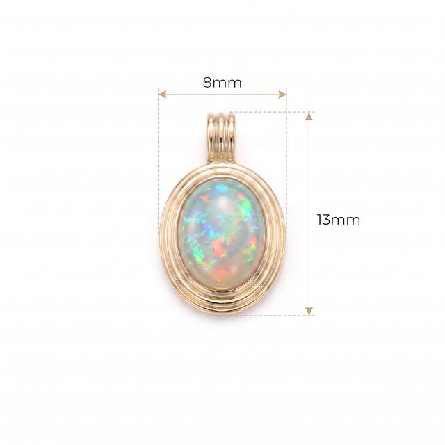 Illuminate your look with the magical play-of-color in this white Opal cabochon pendant. Displaying flashes of neon blue,...