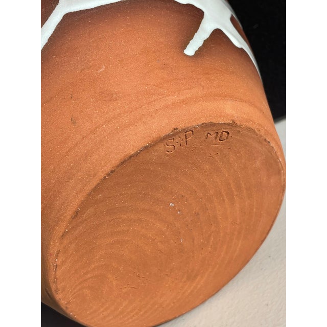 Irish pottery vessel with glossy white slip lining and dramatic brushstroke wraparound design. This piece was made by...