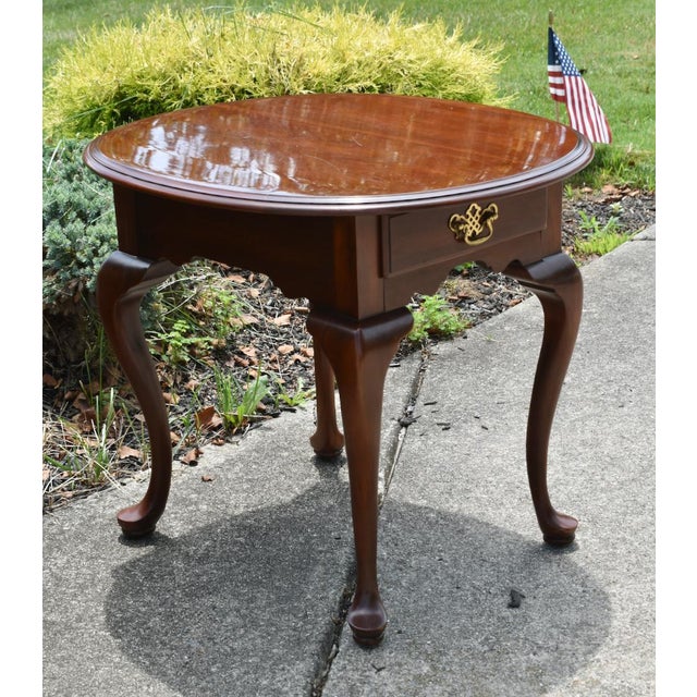 Vintage (1980's) Oval Side Table has a Queen Anne Style. The Wood is CherryWood. The Table has One Drawer w/Brass...