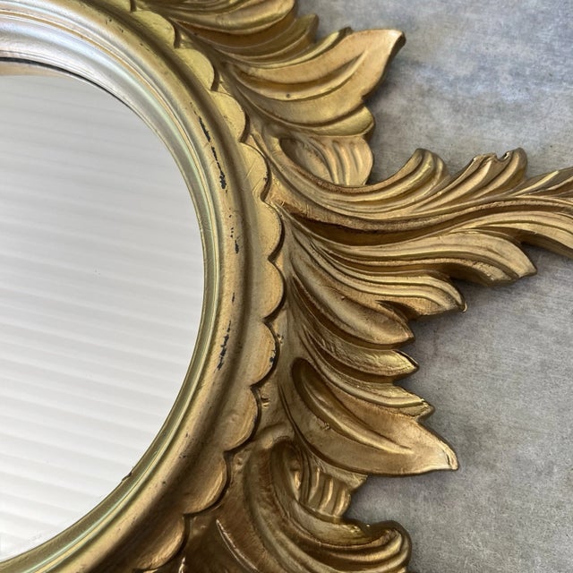 Lovely Mid Century sunburst mirror with a surround of scrolling 'rays'. This Italian mirror has a giltwood patine and is...
