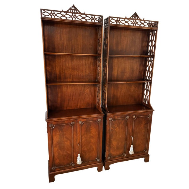 This exceptional pair of antique Chippendale-style étagère cabinets beautifully marries classic English design elements...