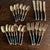 mid-century modern flatware set featuring black riveted handles with warm brass-tone stainless steel. A timeless...