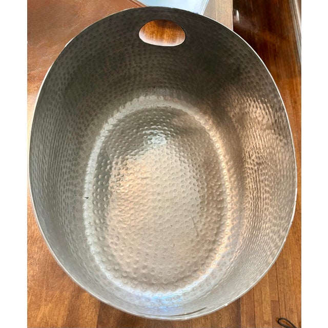 This oval-shaped, dark-colored beverage tub featuring a distinctive hammered texture was designed for chilling and serving...