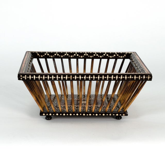 A large Anglo Indian porcupine quill and ebony basket with bone dot and red etched bone inlay resting on turned ebony...