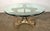 This is a unique coffee table featuring a round glass top and an intricately carved gilt wood base. The base is made of...