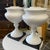 Pair of very stately and classic metal urn table lamps in a white satin finish with black metal base.These are being sold...