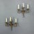 A charming pair of French wrought iron three-arm sconces dating to the 1920s, hand-forged in the Louis XV taste. Crafted...