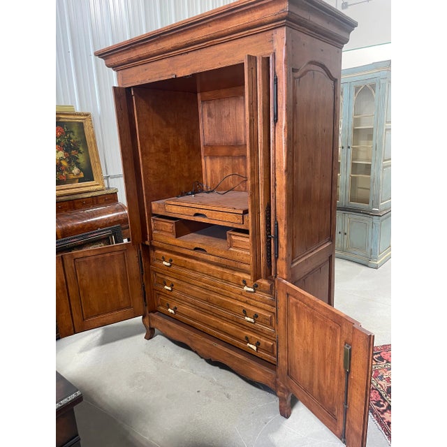 A large entertainment 4-door armoire of cherry wood by Chaddock Furniture. This is a one-piece unit. It features two key-...