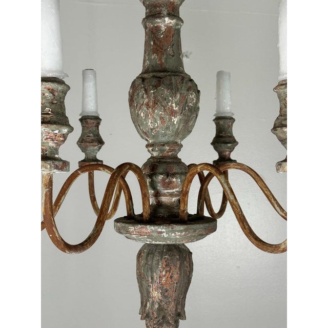 A beautifully timeworn six-light chandelier of European origin, dating to the 19th century, crafted in carved wood with an...
