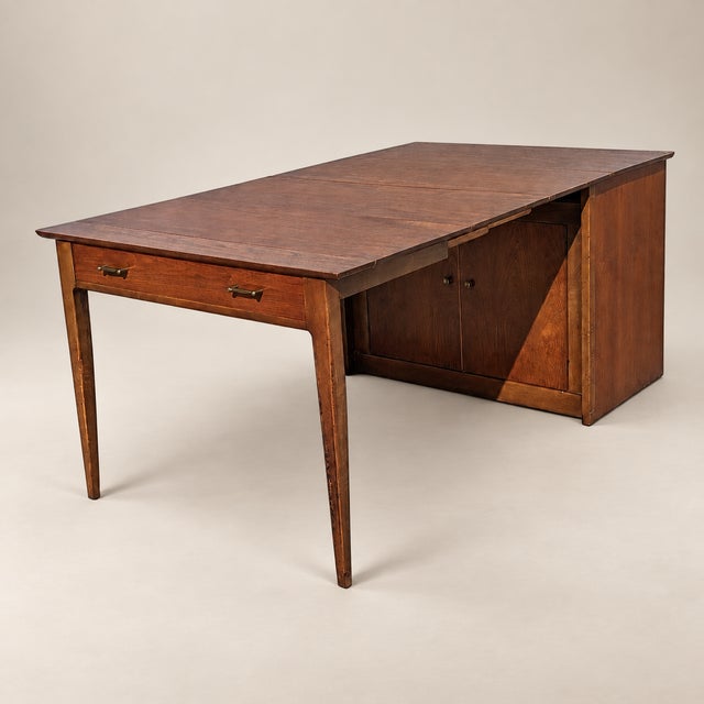 A clever 1960s Saginaw Furniture Extendomatic dining table that converts from a compact walnut cabinet into a full-size...