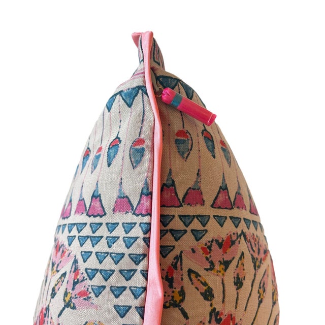 A vibrant mix of color and symmetry, this pillow features a floral medallion pattern in coral, pink, blue, and yellow. It...