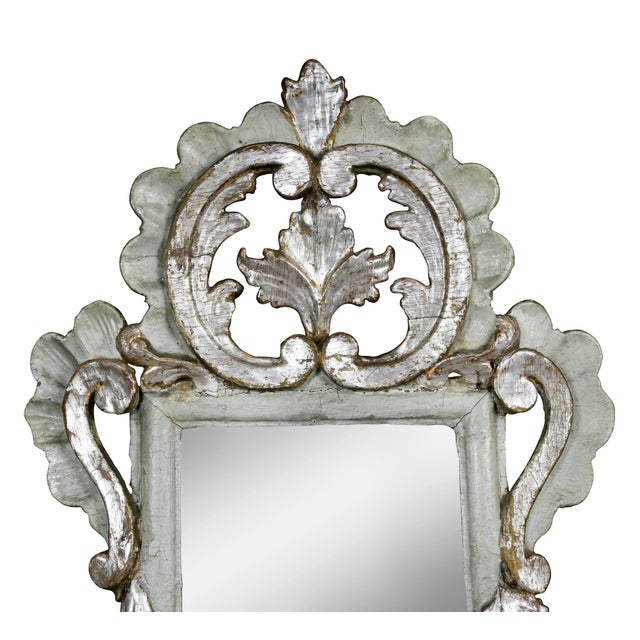Each with a double scroll crest with central opening with leaf, over a mirror plate within a carved frame, similarly...