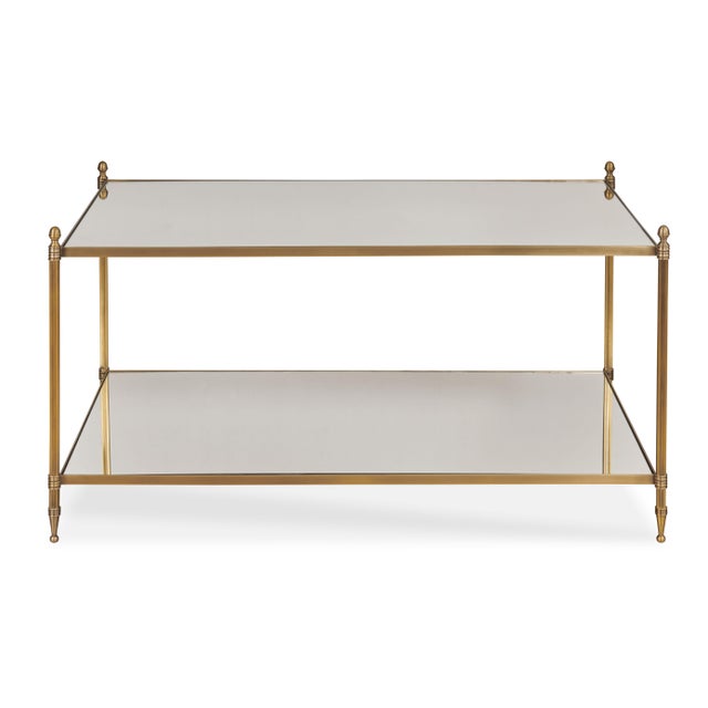 Odesa is an elegant cocktail table made from antique brass with a mirrored top and lower shelf. The delicately scaled...