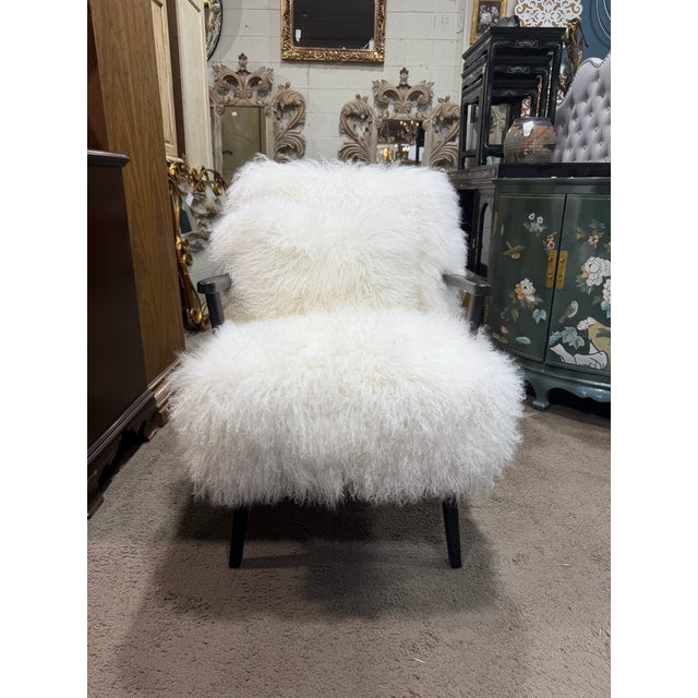 A luxurious and inviting accent chair by Four Hands, upholstered in plush Mongolian sheepskin in a soft ivory hue. The...