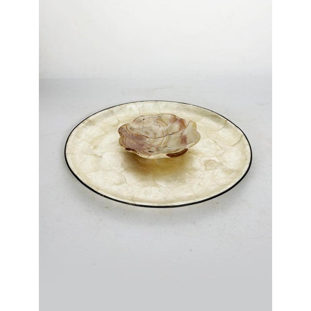 A 20th-century decorative set comprising a large circular platter and a matching small trinket dish. Both pieces feature a...