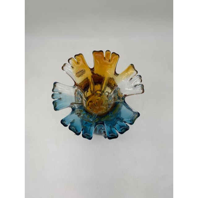 A blown artistic glass vase with a striking sculptural presence, characterized by an organic and dynamic shape that...