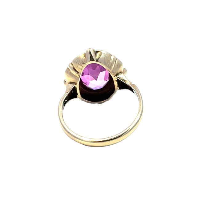 Elevate your jewelry collection with this exquisite vintage ring featuring a stunning oval pink gem, beautifully...