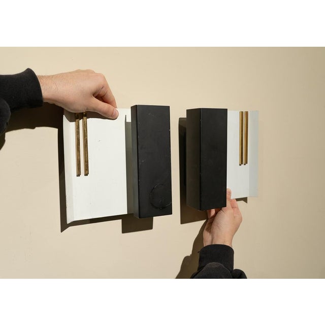 Pair of Spanish wall lights from the 1980s in lacquered metal. They are structured around a rectangular plate of white...