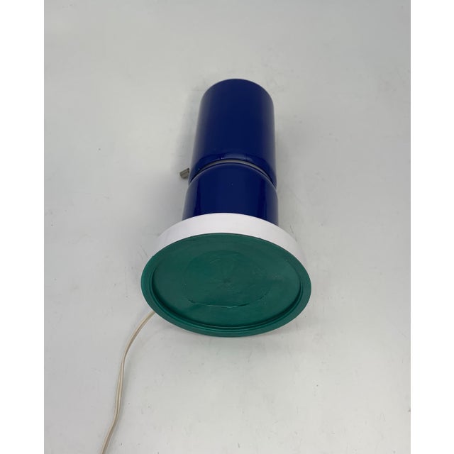 Single table lamp with a modern, geometric design, featuring a cylindrical structure composed of two blue lacquered...