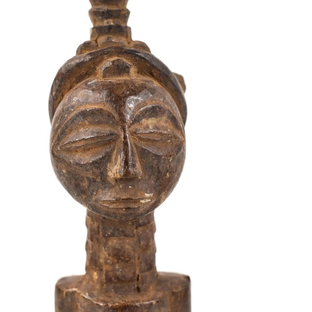 The Luba female figure is crafted as a veneration of feminine beauty and motherhood. Crafted from wood, the Luba female...