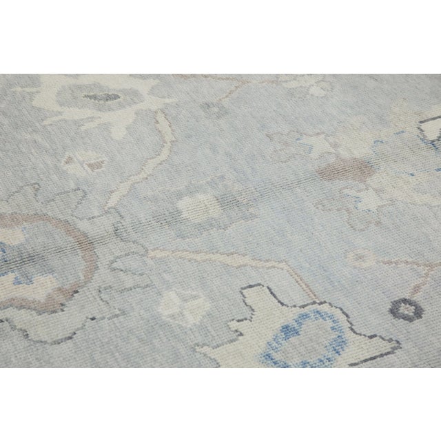 This modern Turkish Oushak rug is a stunning piece of art that has been handwoven using traditional techniques by skilled...