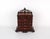 A miniature mahogany chest of drawers in a rich reddish-brown wood grain finish with a pierced, scrolling foliate gallery...