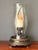 Patinated brass hurricane candle holder by Chapman. Glass hurricane is 7.5” diameter and 18” tall and decorated by...