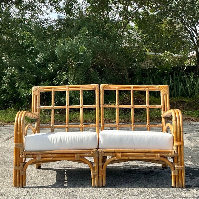 Introduce relaxed coastal elegance to your home with this vintage bent rattan loveseat. Crafted with gracefully curved...