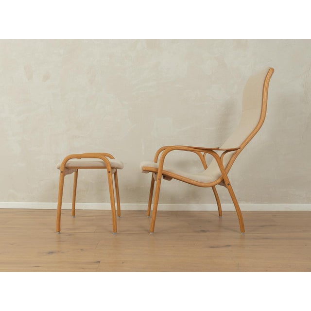 Rare lamino armchair and footstool from the 1950s by yngve ekström for swedese. It features a beautifully curved bent oak...