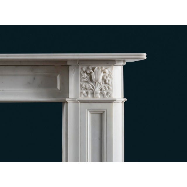 An early-to-mid nineteenth century Regency period fireplace surround in Statuary marble, the shelf with single reed above...