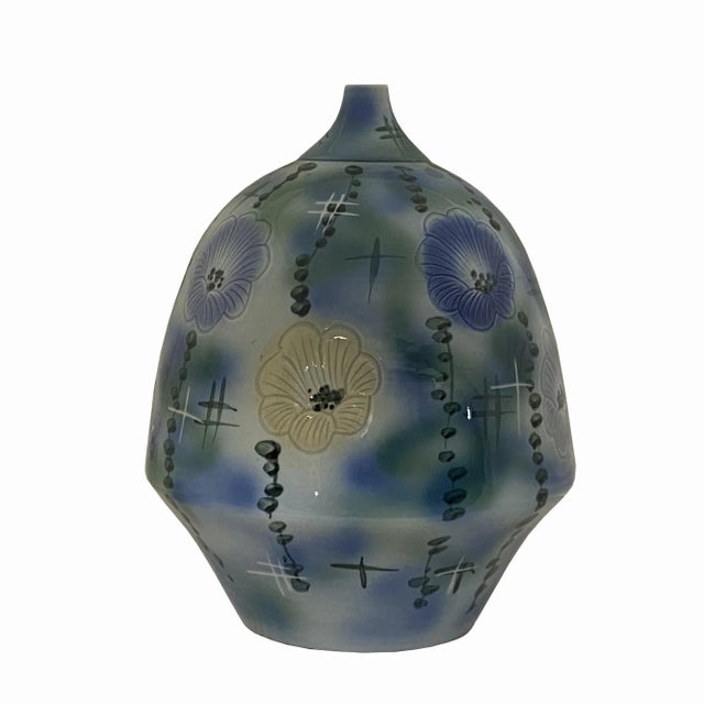 This vase has a fat round body small mouth unique shape, it is finished with a pastel color tone and artistic flower...