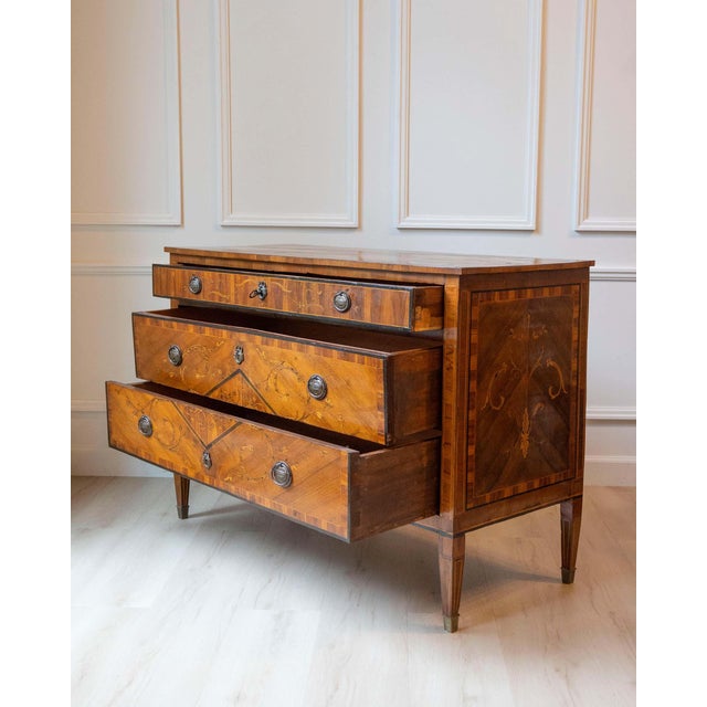 An elegant Italian Louis XVI-period chest of drawers, finely veneered and richly inlaid, dating to the late 18th century....