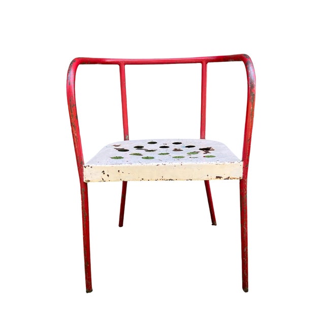 A rare and unusual early 20th century French industrial tubular metal armchair with perforated seat and mottled enameled...