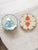 This Anthropologie pair of 9-inch plates features a boho chic pattern with scalloped edges one in coral and one in blue ....