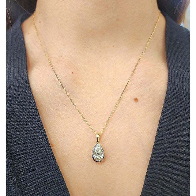 This elegant pendant necklace features a natural pear-cut white diamond, weighing 1.51 carats, with a clarity of SI2 and a...