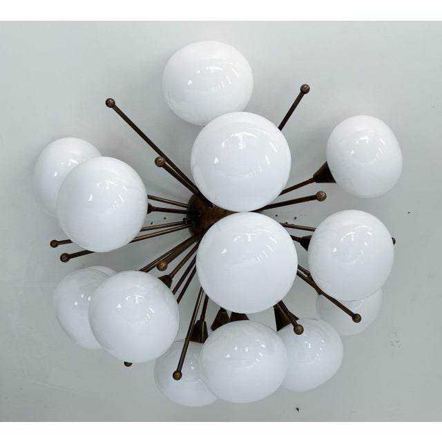 Italian sputnik flush mount with glossy white pebble shaped Murano glass shades mounted on solid brass frame in bronze...