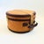 A vintage circular wicker suitcase. Features brass hardware, brown leather trim, and a leather handle. The interior is...