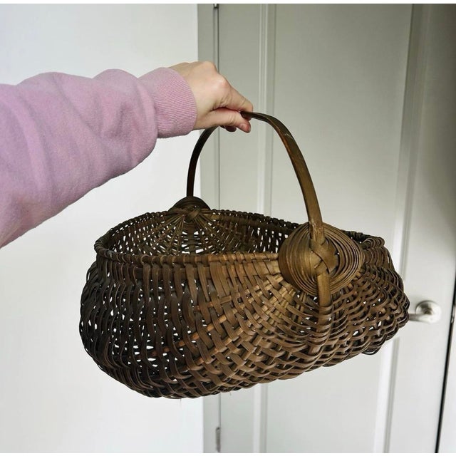 Gorgeous cool brown woven buttock basket with scalloped interior to carry eggs. God’s eye woven details near handle. Some...