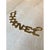 This monumental chain belt spells out the CHANEL name in bold, oversized letters, each cast in a richly textured, hammered...