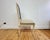 Set of four 1990s reproduction Louis XVI style dining chairs featuring elegantly carved frames with a painted cream finish...
