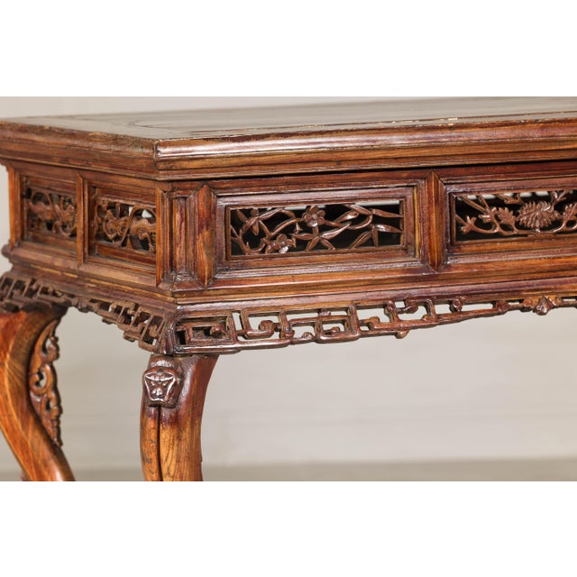A late Qing Dynasty center hall table from the late 19th, early 20th century with hand-carved fretwork motifs. A striking...